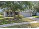 Charming home exterior with well-manicured lawn and mature shade tree at 634 Chadbury Way, Kissimmee, FL 34744
