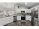 Stylish kitchen featuring stainless steel appliances, granite countertops, and sleek white cabinets, open layout at 634 Chadbury Way, Kissimmee, FL 34744