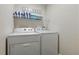 Functional laundry room with a washer, dryer, and shelving for organized storage at 634 Chadbury Way, Kissimmee, FL 34744