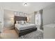 Comfortable bedroom with plush carpeting, a tufted headboard and soft, natural light from the window at 634 Chadbury Way, Kissimmee, FL 34744