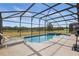 Screened-in pool with an attached spa sits outside the home in the backyard at 634 Chadbury Way, Kissimmee, FL 34744