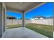 Covered back patio overlooks fenced backyard with healthy grass and privacy at 690 Blue Citrus Ln, Minneola, FL 34715
