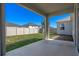 Covered back patio overlooks fenced backyard with healthy grass and privacy at 690 Blue Citrus Ln, Minneola, FL 34715
