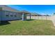 Grassy backyard features a covered patio area and fencing for privacy at 690 Blue Citrus Ln, Minneola, FL 34715