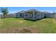 Spacious backyard features a covered patio, lush green grass, and privacy fence at 690 Blue Citrus Ln, Minneola, FL 34715