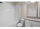 Bathroom featuring a white vanity with granite countertop, tiled shower and white subway tile at 690 Blue Citrus Ln, Minneola, FL 34715