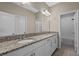 Bright bathroom featuring double vanity with granite countertop and tiled floor and combination tub shower at 690 Blue Citrus Ln, Minneola, FL 34715