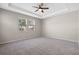 Spacious bedroom boasts tray ceiling, neutral paint and plush carpeting at 690 Blue Citrus Ln, Minneola, FL 34715