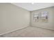 Empty bedroom showcasing neutral walls, two windows with blinds, and plush carpeting at 690 Blue Citrus Ln, Minneola, FL 34715
