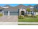 Beautiful single-Gathering home with a paver driveway, stone accents, and a well-manicured lawn at 690 Blue Citrus Ln, Minneola, FL 34715