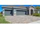 Beautiful single-story home featuring a three-car garage and a brick-paved driveway, offering both convenience and curb appeal at 690 Blue Citrus Ln, Minneola, FL 34715