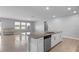 Open-concept kitchen island offers additional seating and overlooks a living area filled with natural light from large windows at 690 Blue Citrus Ln, Minneola, FL 34715