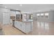 Open-concept kitchen with granite counters, a center island, stainless steel appliances, and seamless flow into the living space at 690 Blue Citrus Ln, Minneola, FL 34715