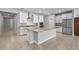 Spacious kitchen features a large center island, stainless steel appliances, and ample storage in its bright white cabinets at 690 Blue Citrus Ln, Minneola, FL 34715