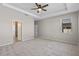 The main bedroom offers an ensuite bath, tray ceiling, ceiling fan and plush carpeting at 690 Blue Citrus Ln, Minneola, FL 34715