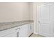Pantry includes granite counters, white cabinets, and tile flooring at 690 Blue Citrus Ln, Minneola, FL 34715