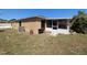 Exterior showcasing the home's screened lanai, a small grill area, and lush landscaping in the yard at 712 Leonardo Ct, Kissimmee, FL 34758