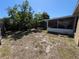 Large, partially-shaded backyard with mature trees and a screened-in lanai at 712 Leonardo Ct, Kissimmee, FL 34758