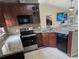 Kitchen area with stainless appliances, wood cabinets, granite counter tops and peninsula with breakfast bar at 712 Leonardo Ct, Kissimmee, FL 34758
