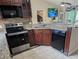 Kitchen area with stainless appliances, wood cabinets, granite counter tops and peninsula with breakfast bar at 712 Leonardo Ct, Kissimmee, FL 34758