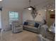 Relaxing living room with a plush grey sofa, recliner, and decorative wall accents at 712 Leonardo Ct, Kissimmee, FL 34758