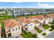 Aerial view of a residential area featuring modern homes with tile roofs and landscaped lawns in a planned community at 8991 Fluffy Lie Ct, Davenport, FL 33896