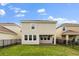 Backyard with a green lawn, black iron fence, and an exterior view of the two-story home at 8991 Fluffy Lie Ct, Davenport, FL 33896