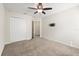 Bedroom features carpet, ceiling fan, double door closet, and a TV mount at 8991 Fluffy Lie Ct, Davenport, FL 33896