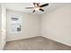 A light-filled bedroom featuring carpet floors, a ceiling fan, and a window at 8991 Fluffy Lie Ct, Davenport, FL 33896