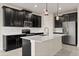Modern kitchen with stainless steel appliances, an island and dark wood cabinets at 8991 Fluffy Lie Ct, Davenport, FL 33896