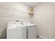 Convenient laundry room equipped with a washer, dryer, and overhead shelving for storage at 8991 Fluffy Lie Ct, Davenport, FL 33896