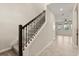View of the staircase with carpet steps and rod iron spindles leading to the upper level at 8991 Fluffy Lie Ct, Davenport, FL 33896