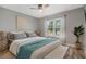Cozy bedroom with a ceiling fan, large sunlit window, and warm decor at 907 Ridge Spring Ct, Apopka, FL 32712