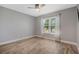 A well-lit empty bedroom with a sunlit window and hardwood floors at 907 Ridge Spring Ct, Apopka, FL 32712
