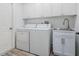 Well-lit laundry room with white cabinets, a stainless steel sink, a washer, and a dryer at 907 Ridge Spring Ct, Apopka, FL 32712