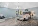 Comfortable primary bedroom featuring an elegant chandelier, accent lamps, and two large sunlit windows at 907 Ridge Spring Ct, Apopka, FL 32712