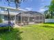 A beautiful screened lanai sits in the backyard with a jacuzzi and ample space for seating at 9076 Lake Avon Dr, Orlando, FL 32829