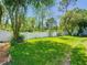 Well-maintained backyard features lush green grass, a white fence, and mature trees for shade at 9076 Lake Avon Dr, Orlando, FL 32829