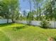 Well-maintained backyard features lush green grass, a white fence, and blooming rose bushes at 9076 Lake Avon Dr, Orlando, FL 32829