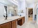 Bathroom featuring walk-in shower, double vanity, large mirror, and walk-in closet at 9076 Lake Avon Dr, Orlando, FL 32829
