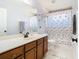 Bathroom featuring a vanity with storage and a shower/tub combo with a decorative shower curtain at 9076 Lake Avon Dr, Orlando, FL 32829