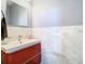 Modern bathroom with marble walls, bright vanity, a vessel sink, and designer fixtures at 9076 Lake Avon Dr, Orlando, FL 32829