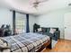 Comfortable bedroom featuring a plaid comforter, stylish sofa, and a well-lit window at 9076 Lake Avon Dr, Orlando, FL 32829