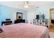 Bright bedroom features a soft pink bedspread, blue walls, and a ceiling fan for added comfort at 9076 Lake Avon Dr, Orlando, FL 32829