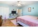 A bright and colorful bedroom featuring a ceiling fan, soft lighting, and hardwood floors at 9076 Lake Avon Dr, Orlando, FL 32829