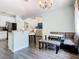 Eat-in kitchen area featuring a banquette, a chandelier, large window and sleek wood flooring at 9076 Lake Avon Dr, Orlando, FL 32829