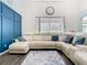 Cozy living room features a cream sectional and view to backyard at 9076 Lake Avon Dr, Orlando, FL 32829
