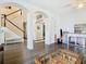 Spacious living room featuring hardwood floors, arches, and stairway with a black railing at 9076 Lake Avon Dr, Orlando, FL 32829