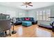 Comfortable home office with a ceiling fan, hardwood floors, and lots of light from large windows at 9076 Lake Avon Dr, Orlando, FL 32829