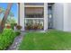 Low-angle shot of a building with a lawn, trees, and bushes in front of the main glass door and windows at 11 Escondido Cir # 110, Altamonte Springs, FL 32701
